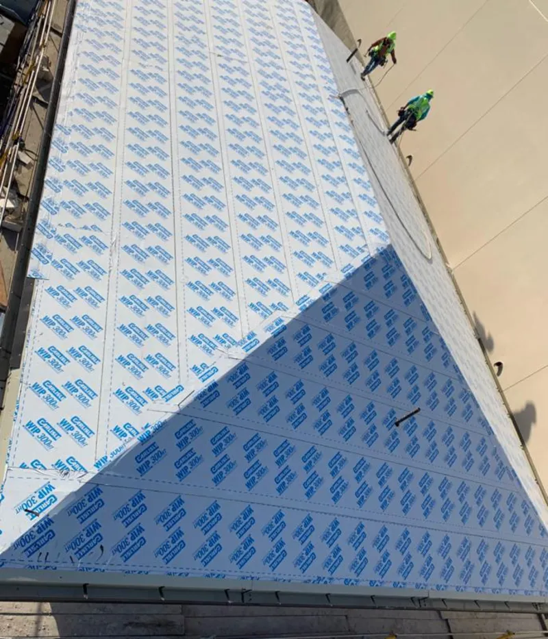 Professional roofers installing underlayment on a metal roof in Titusville